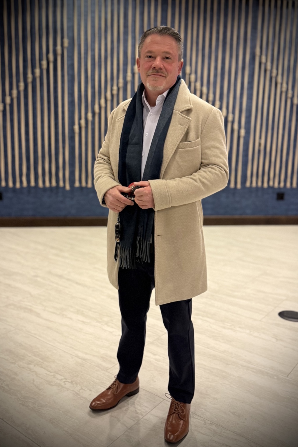 Author David C. Finnegan wearing a tan coat and navy scarf